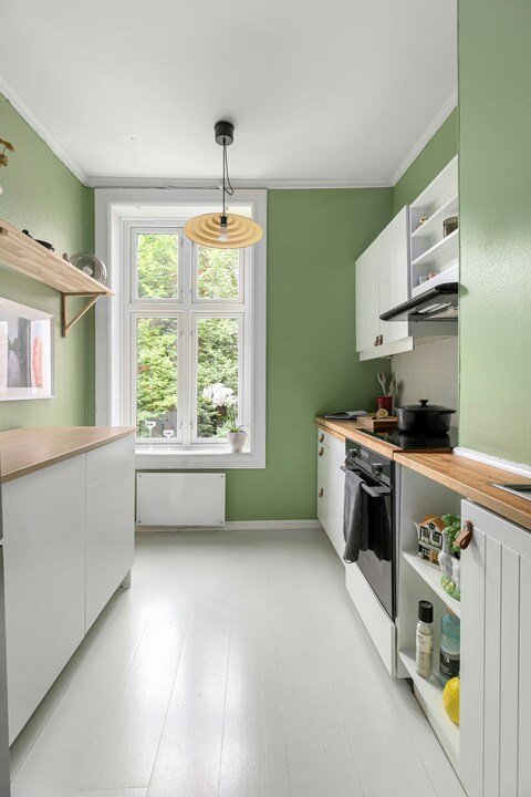 Peinture petite cuisine lumineuse Nantes par Gwenaël Le Reste. Peindre une cuisine étroite Nantes murs vert clair meubles blancs par peintre intérieur.