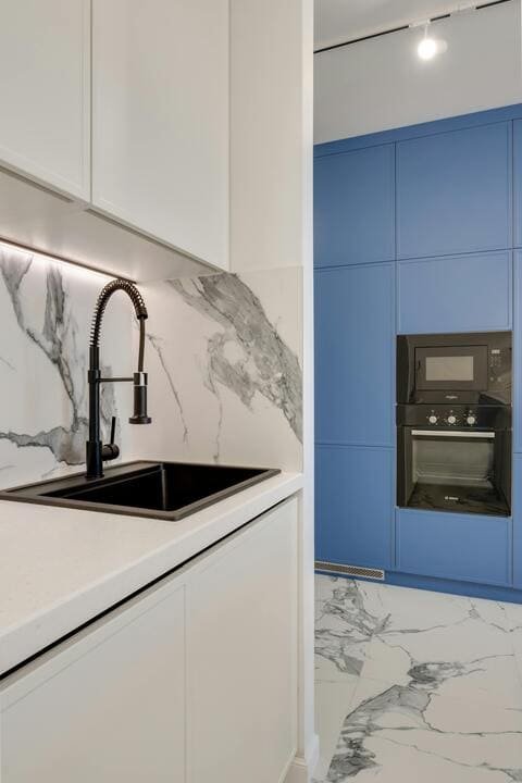 Cuisine design avec mur bleu et peinture murale contrastée – GLR Peinture Nantes Cuisine contemporaine avec crédence marbrée et mur bleu peint
